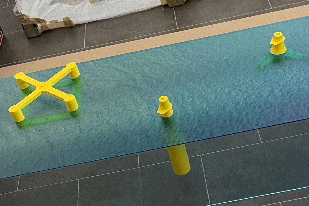 Wind turbine base structures in seabed apertures